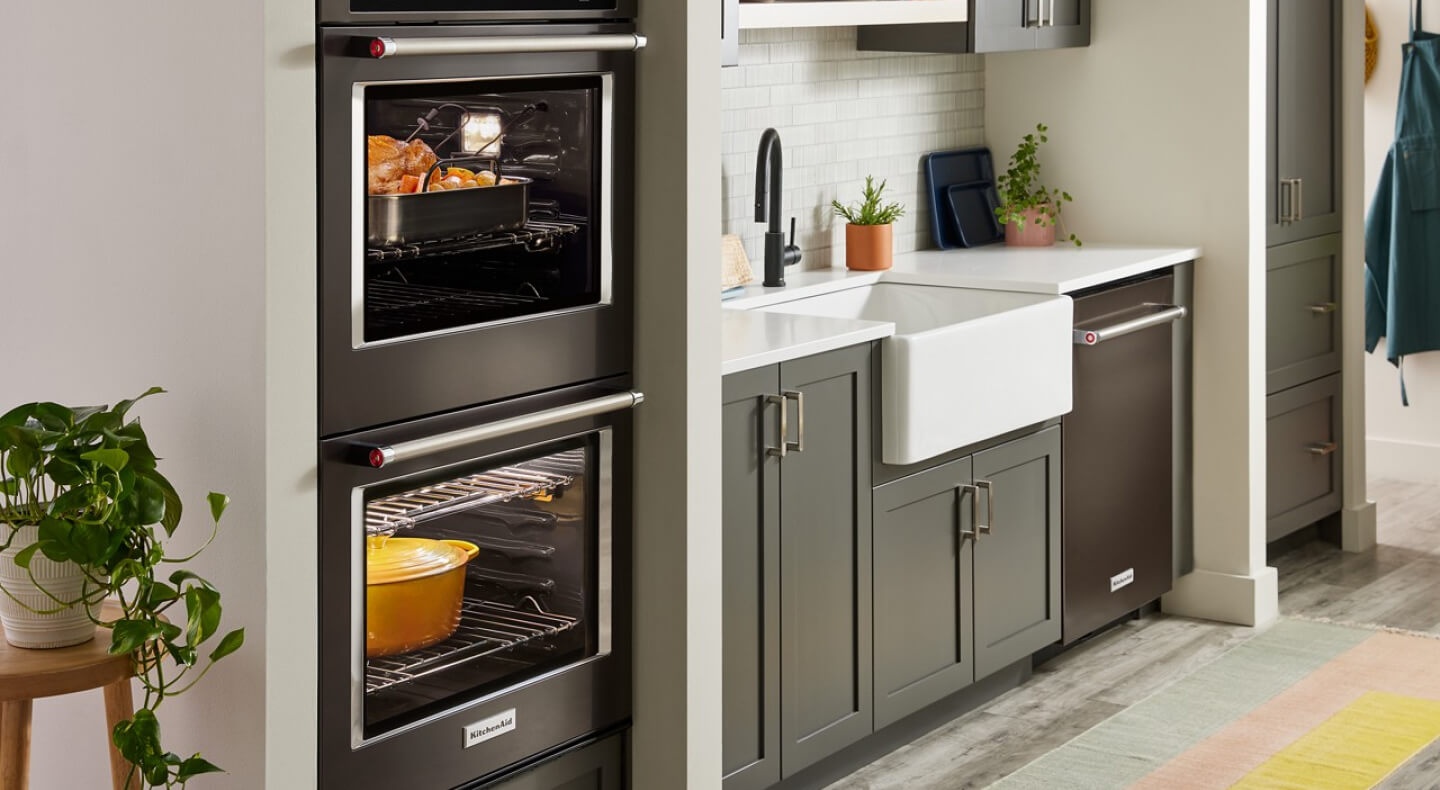 A sleek KitchenAid® double wall oven with a whole chicken and stew cooking in separate cavities