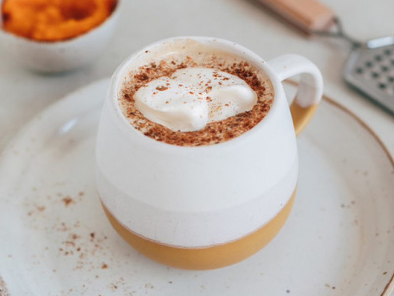 Whipped coffee in a mug on a tea plate Whipped coffee in a mug on a tea plate