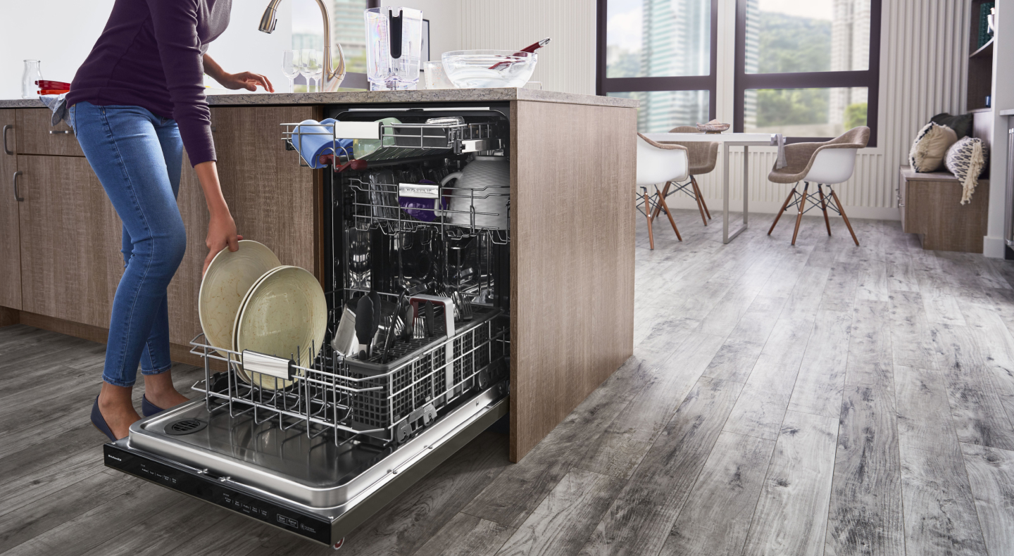 Person unloading dishwasher Person unloading dishwasher