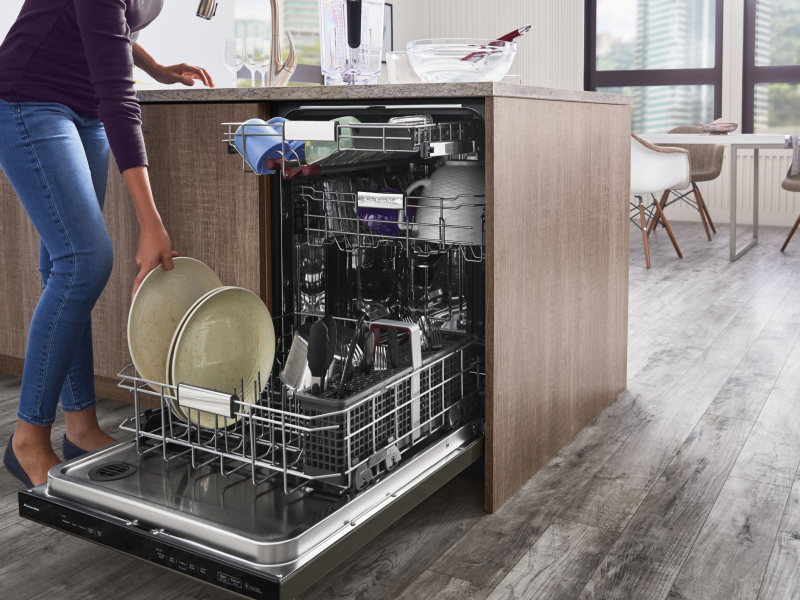 Person unloading dishwasher Person unloading dishwasher