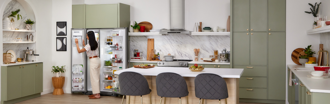 Person standing in front of an open refrigerator in a contemporary kitchen