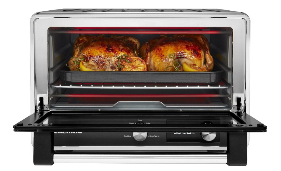 Open countertop oven with two roasted chickens inside