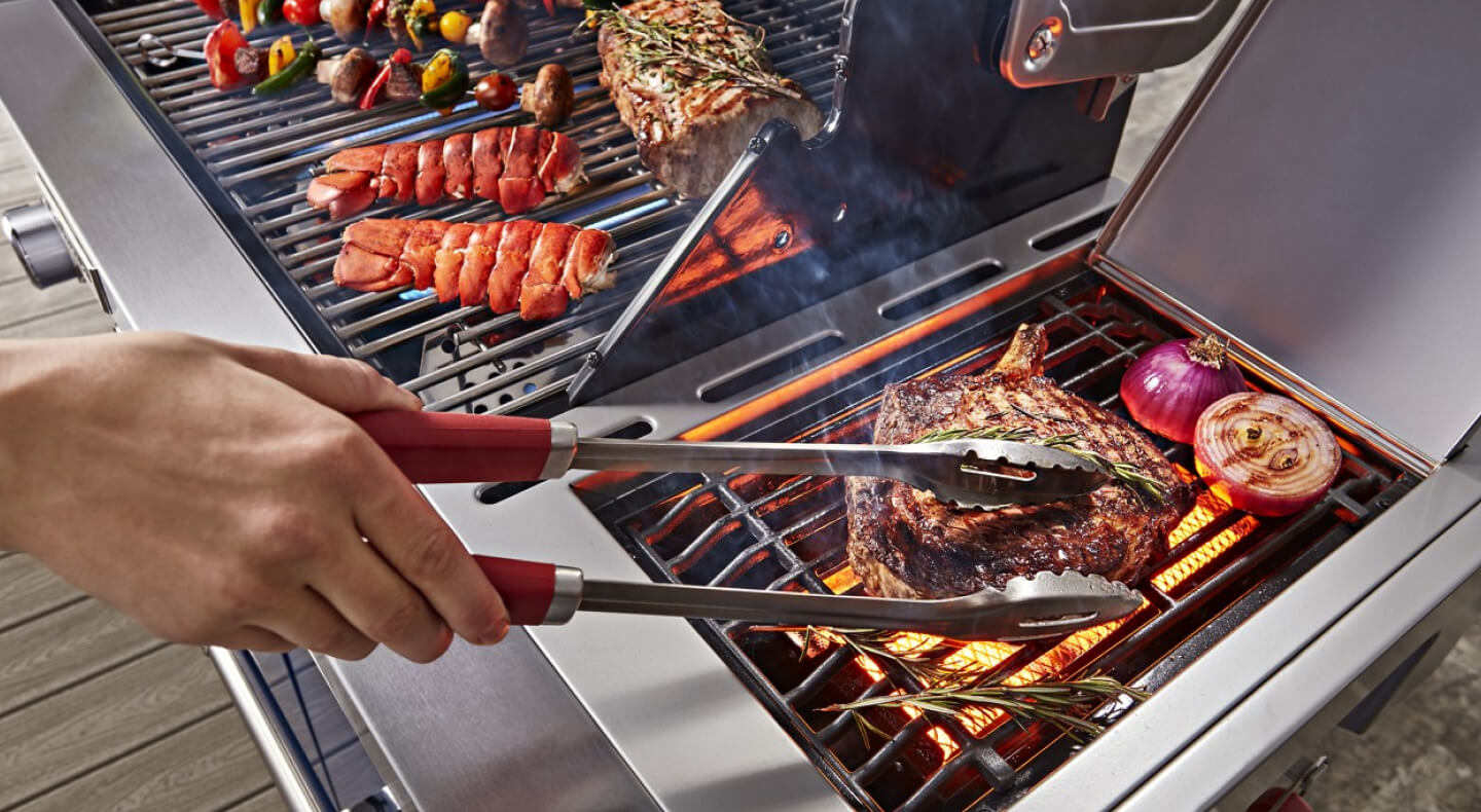 Person grilling steak and vegetables on an outdoor grill Person grilling steak and vegetables on an outdoor grill