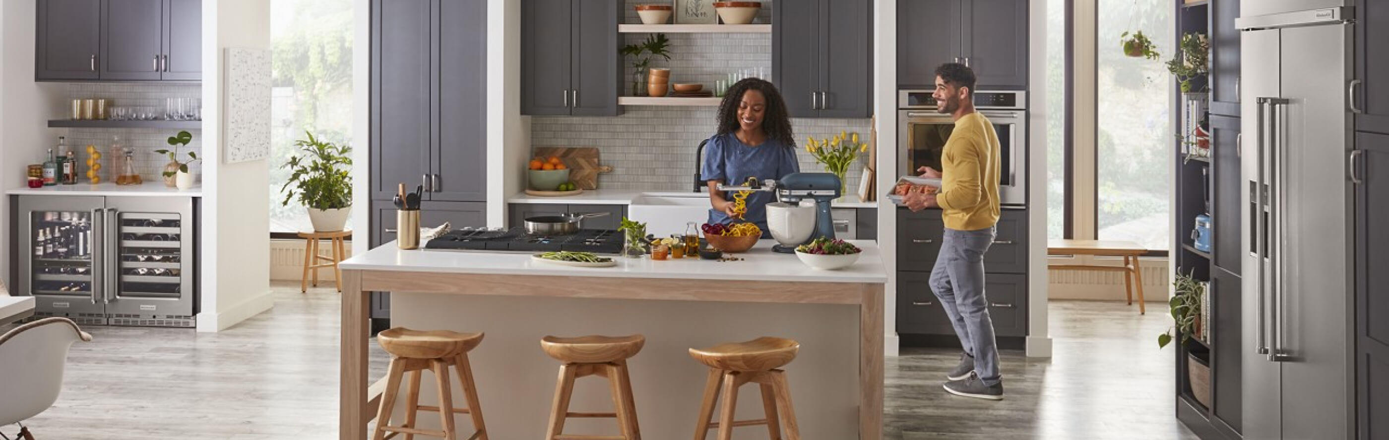 Two people in an open concept kitchen with a kitchen island