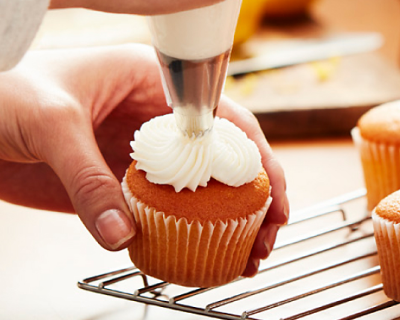 Cream cheese frosting piped onto a cupcake