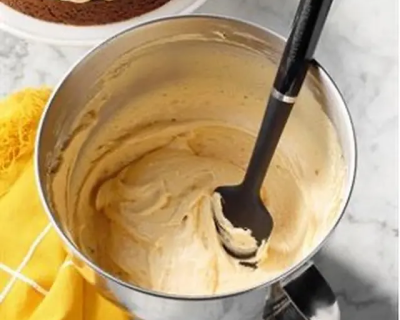 Whipped cream frosting and a spatula in a bowl