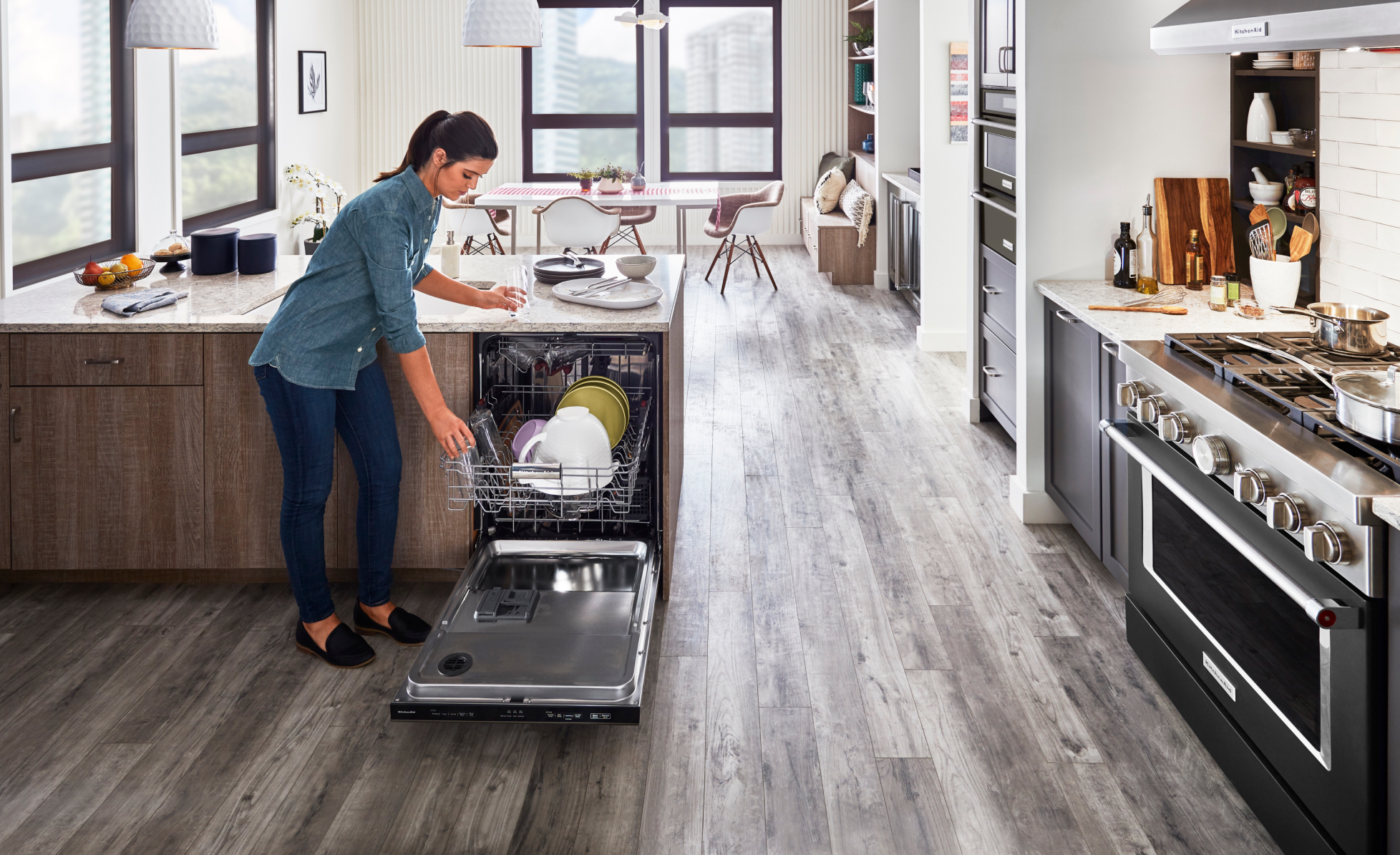 Person putting dishers in a KitcheAid® diswasher.