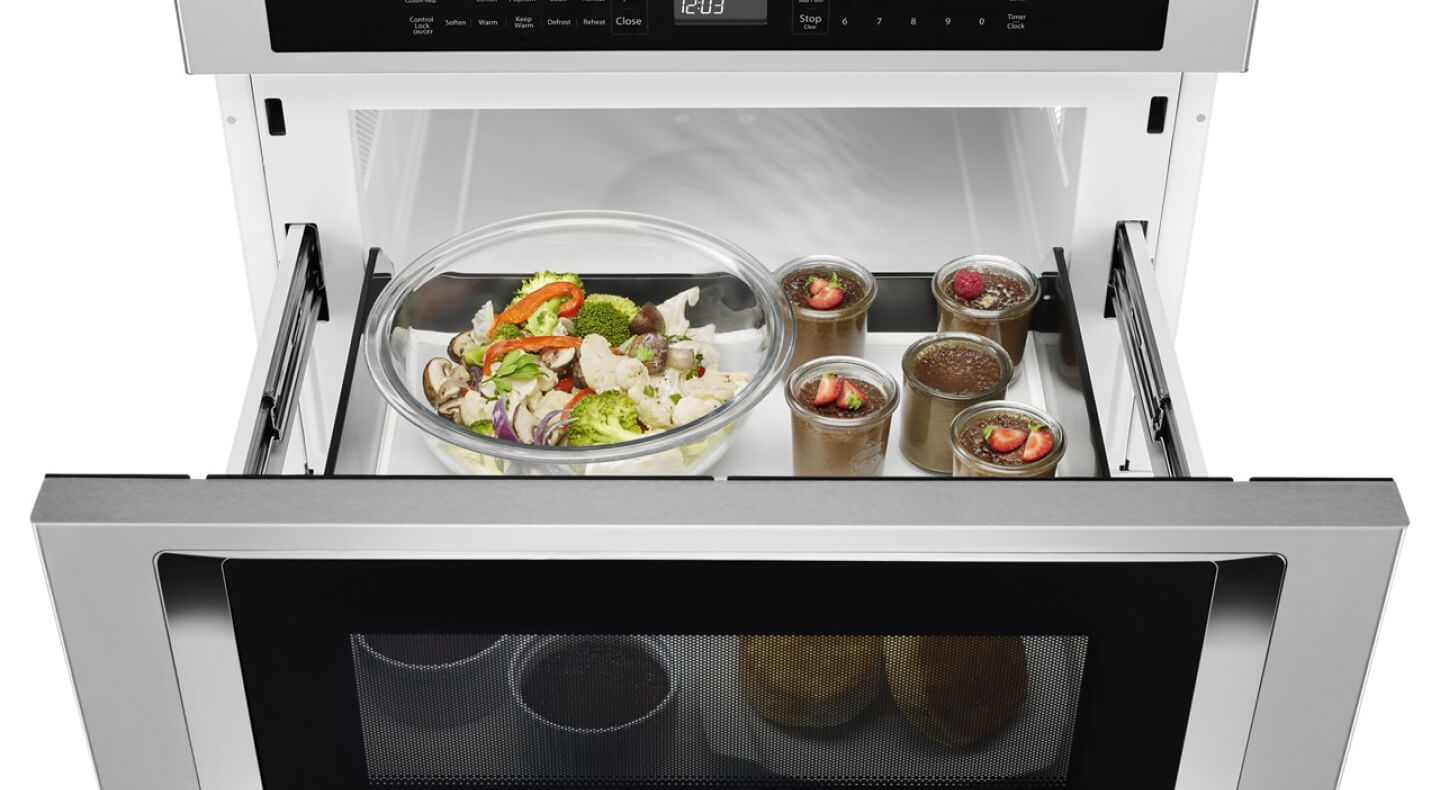 An open KitchenAid® undercounter microwave oven drawer with an assortment of food inside An open KitchenAid® undercounter microwave oven drawer with an assortment of food inside