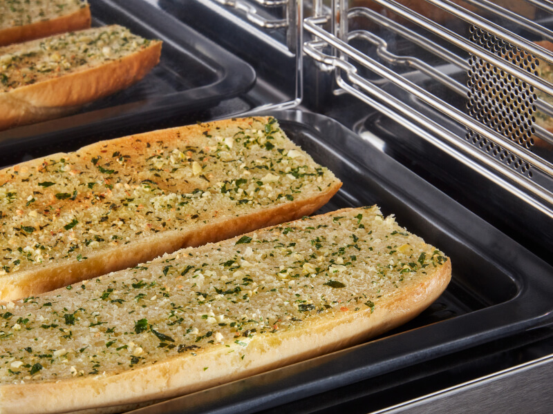 Close-up of garlic bread cooking in a microwave