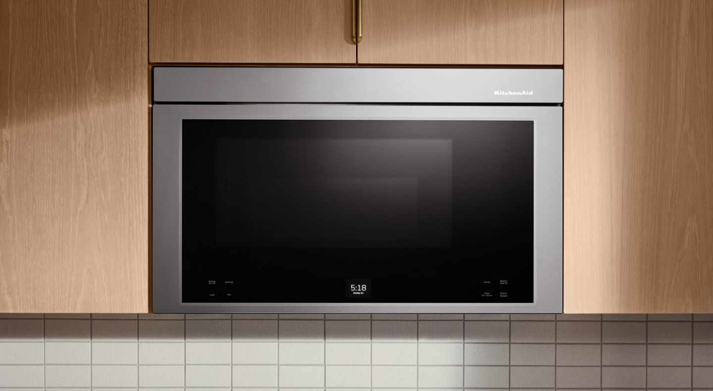 Stainless KitchenAid® over-the-range microwave in light brown cabinetry 