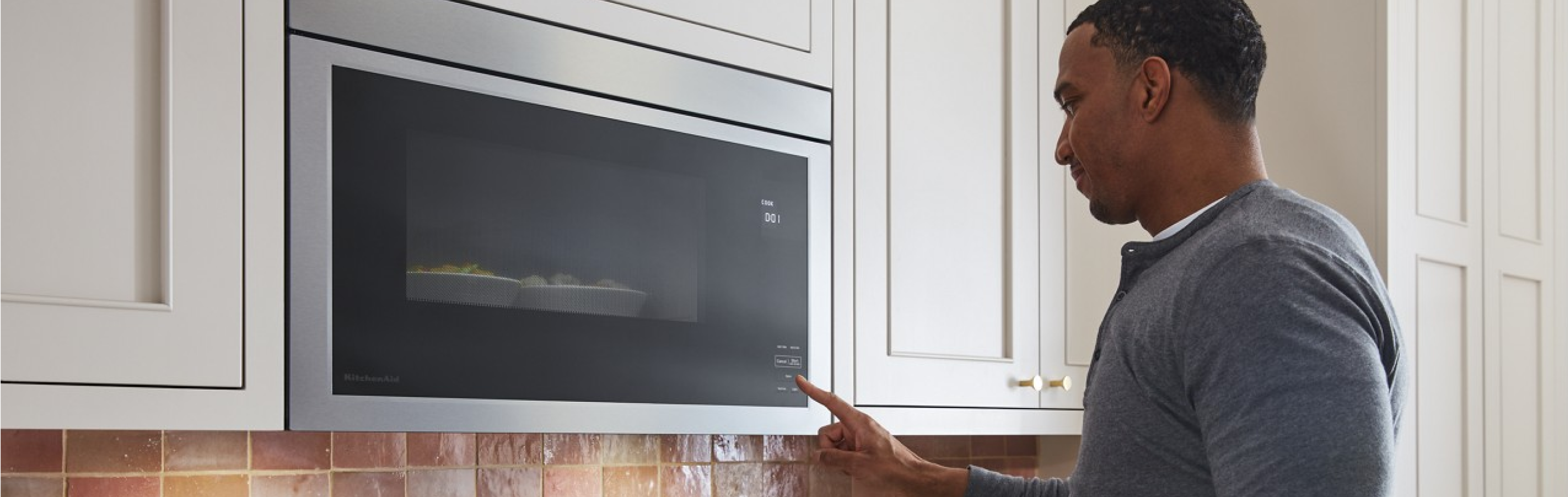 Person selecting settings on an over-the-range microwave