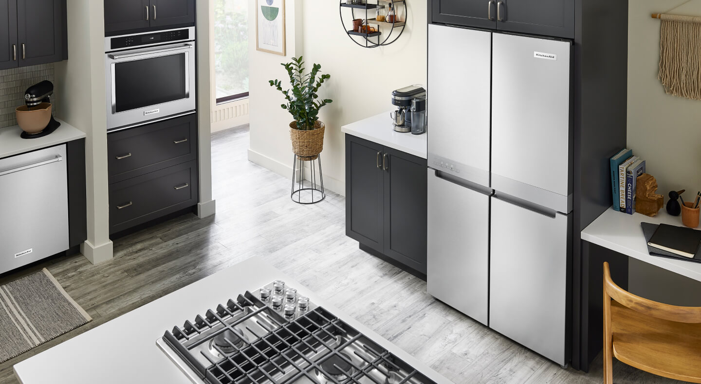 A sleek KitchenAid® four door refrigerator with a suite of appliances