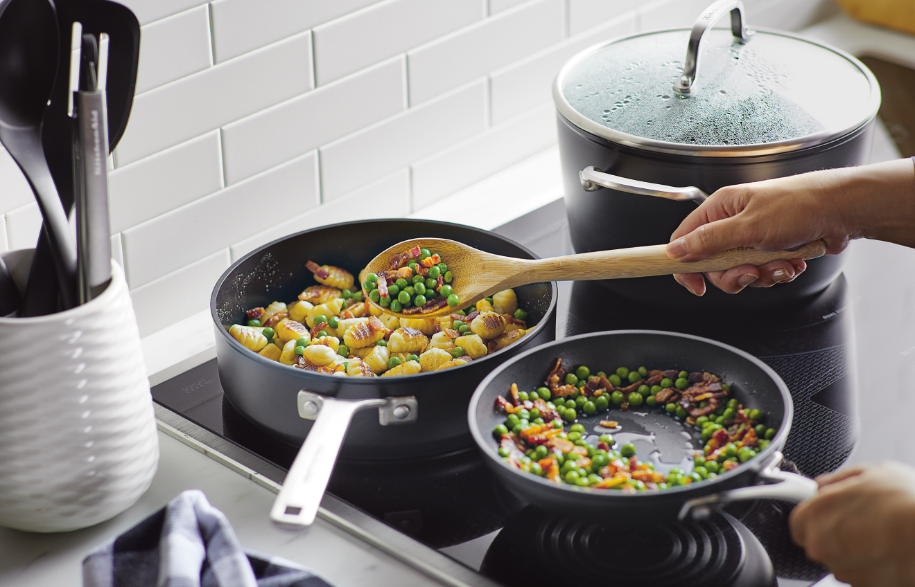 Person preparing a meal with KitchenAid® Traditional Nonstick Cookware