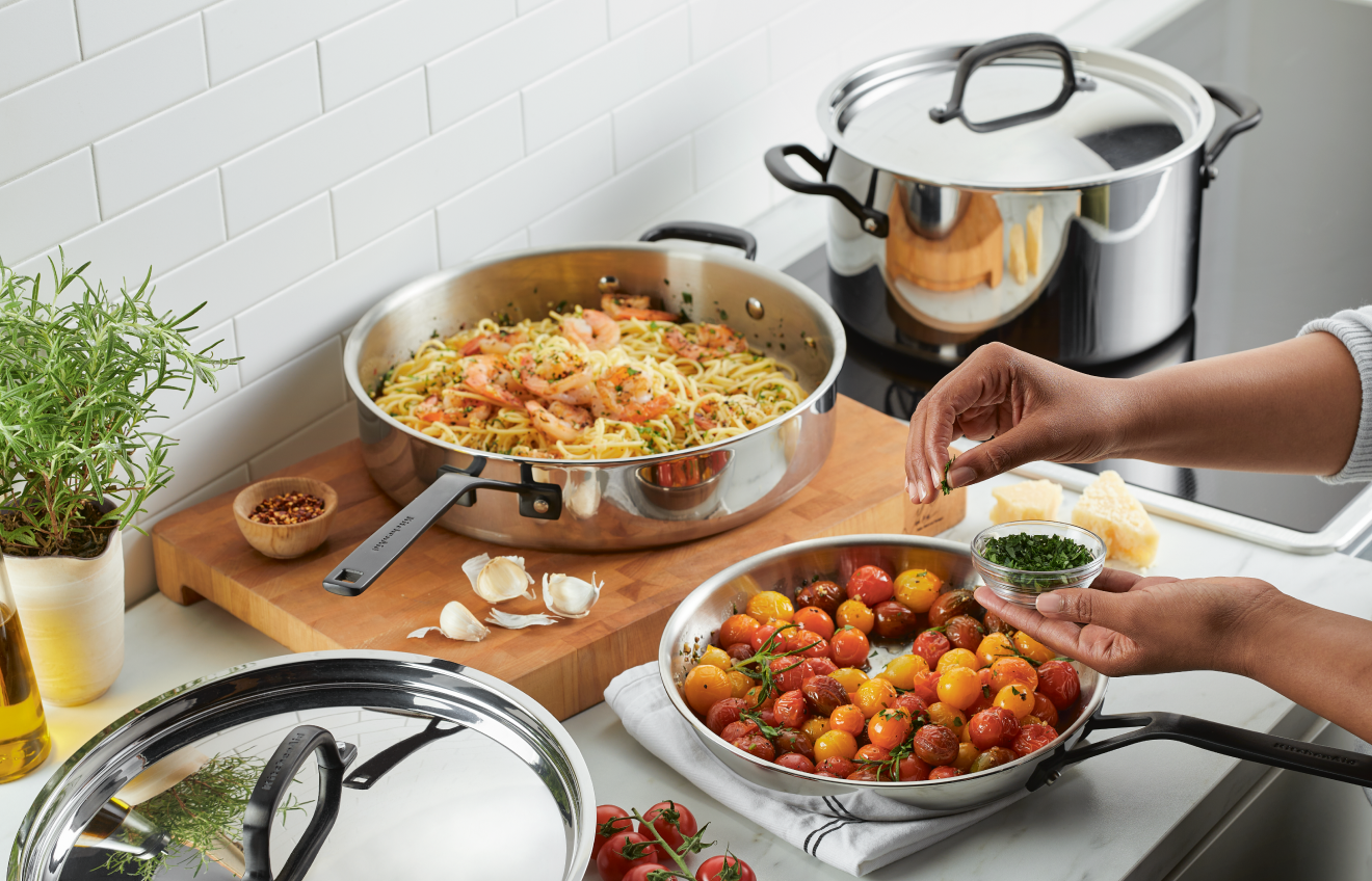 Person preparing a meal with KitchenAid® Stainless Steel Cookware