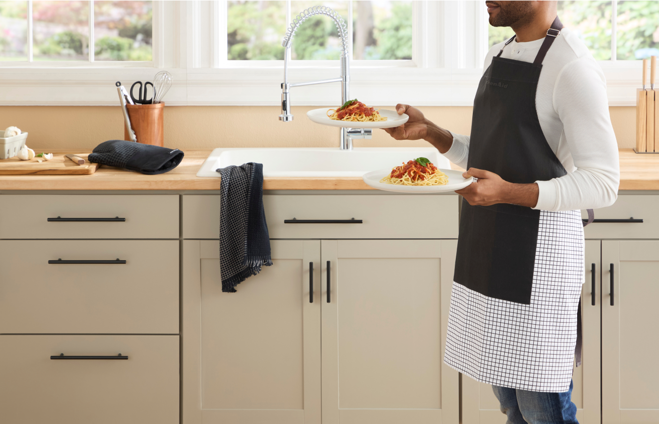 Person serving a meal wearing a KitchenAid® Apron.