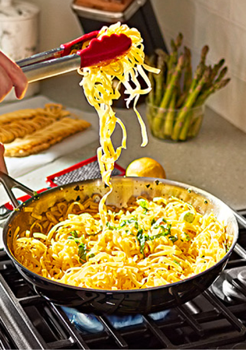 Person cooking on KitchenAId cooktop