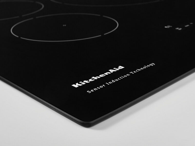 Closeup of a KitchenAid brand induction cooktop’s surface