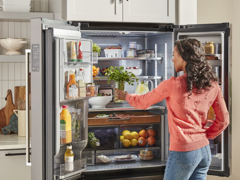 Person putting food in a refrigerator