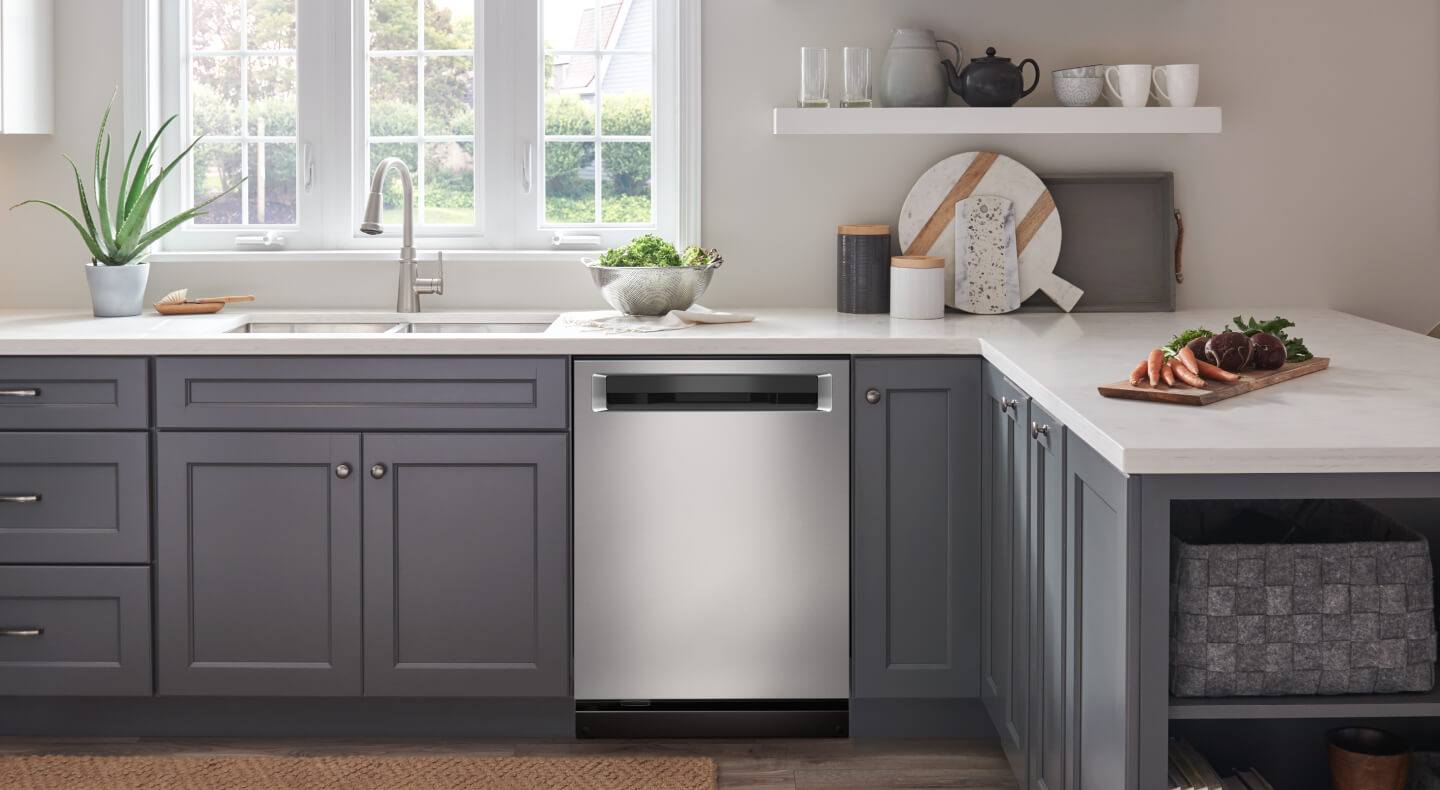 KitchenAid® stainless steel dishwasher with a pocket handle in blue-gray cabinetry