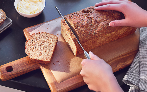 Home cook cutting into a loaf of banana bread