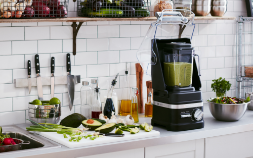 Commercial blender on a counter with cut vegetables