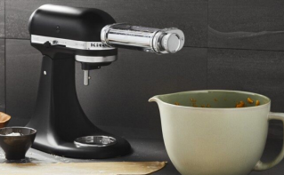 A black stand mixer with pasta attachment.