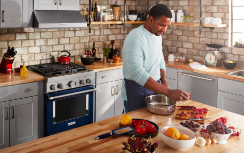 Person marinating meat in a kitchen with an island