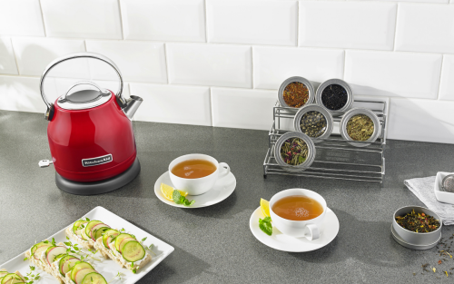 Red KitchenAid® electric kettle next to two cups of tea