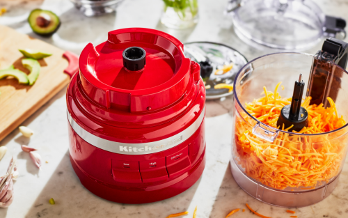 Red KitchenAid® food processor with shredded cheese in it