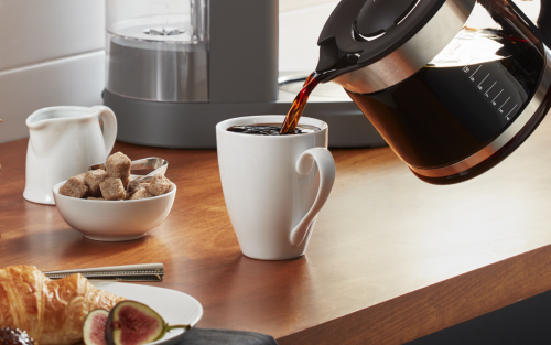 Coffee being poured into white coffee cup