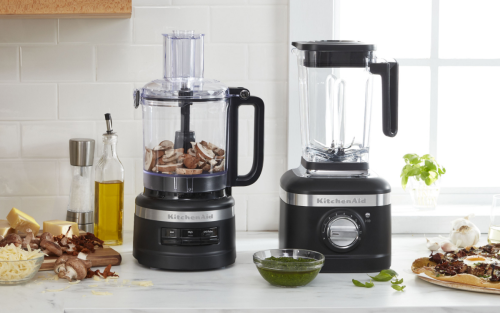 Food processor and blender on kitchen counter with ingredients