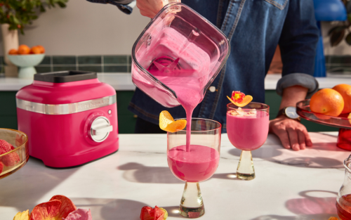 Frozen pink cocktails being poured from blender to glass