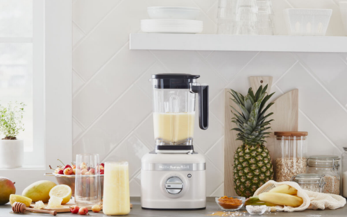 Silver KitchenAid® blender next to pineapples, bananas and lemons