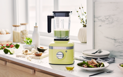 Yellow KitchenAid® blender next to a cutting board and produce