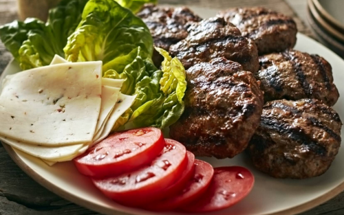 Burger patties, cheese slices and lettuce on platter