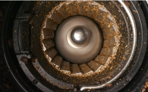 Inside a burr grinder as it grinds coffee