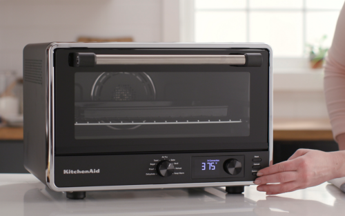 Woman selecting settings on countertop oven air fryer