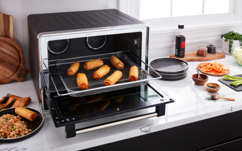 Egg rolls being removed from a toaster oven