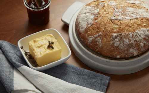 Loaf of sourdough bread next to dish of butter