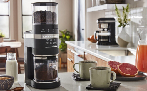 KitchenAid® Burr Coffee Grinder with coffee cups and grapefruit halves.