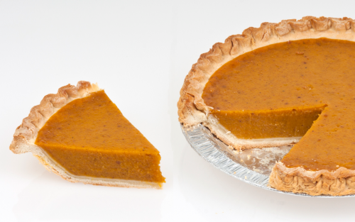 Whole pumpkin pie with one slice cut out to the side