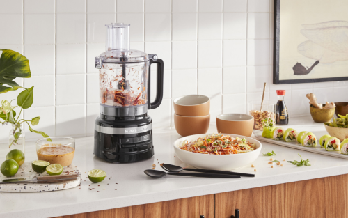 KitchenAid® food processor on countertop with sushi and cole slaw