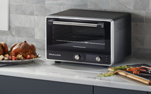  KitchenAid countertop oven with roasted chicken and vegetables on the side