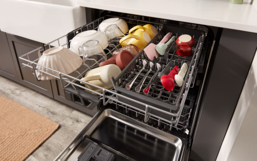Third rack of a KitchenAid® dishwasher filled with utensils, bowls and mugs