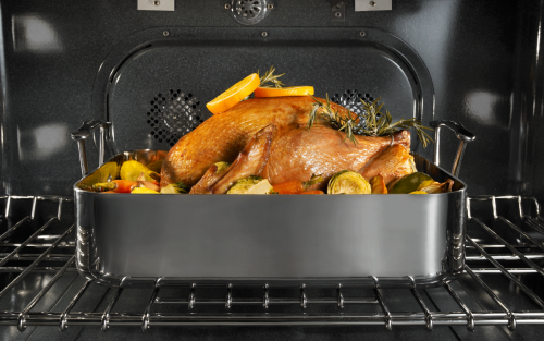 Full turkey in an oven seasoned with herbs and vegetables