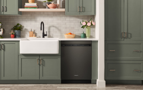 Black dishwasher in a green kitchen