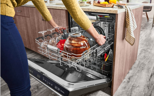 Dirty wine glasses and mixing bowl in the top rack of a dishwasher