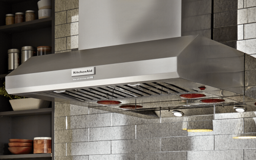 A KitchenAid® range hood against a backdrop of kitchen cabinets