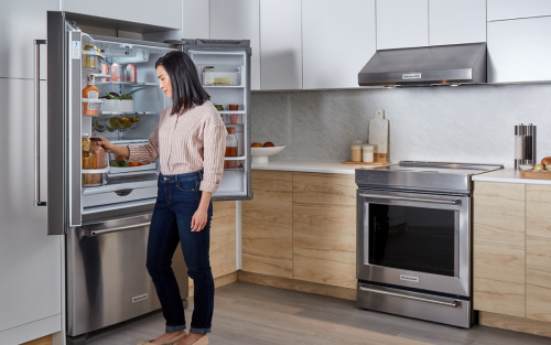 Person placing an item inside a French door refrigerator 