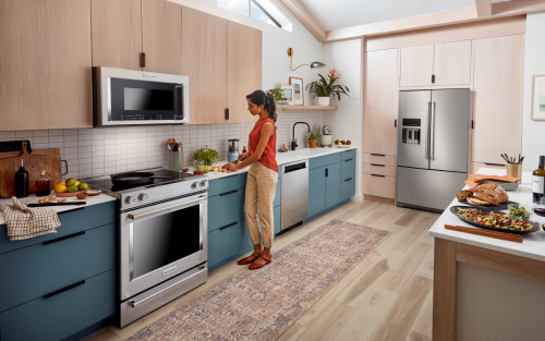 A kitchen with wood cabinets and a french door stainless steel refrigerator